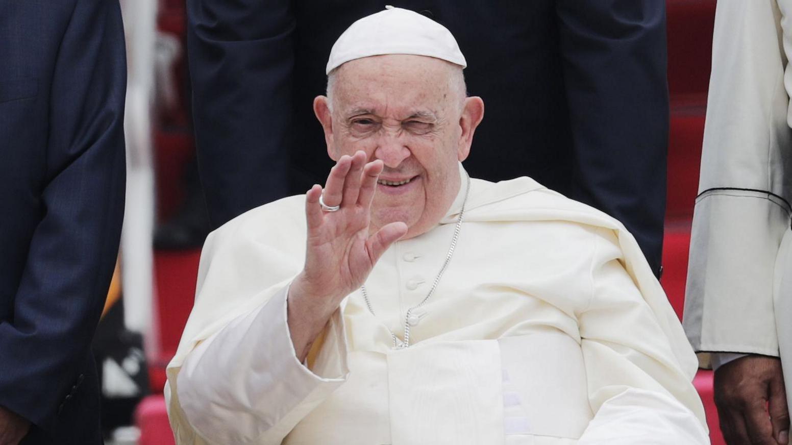 Pope Francis waves after disembarking from an airplane during his arrival at Soekarno-Hatta International Airport in Jakarta, Indonesia.