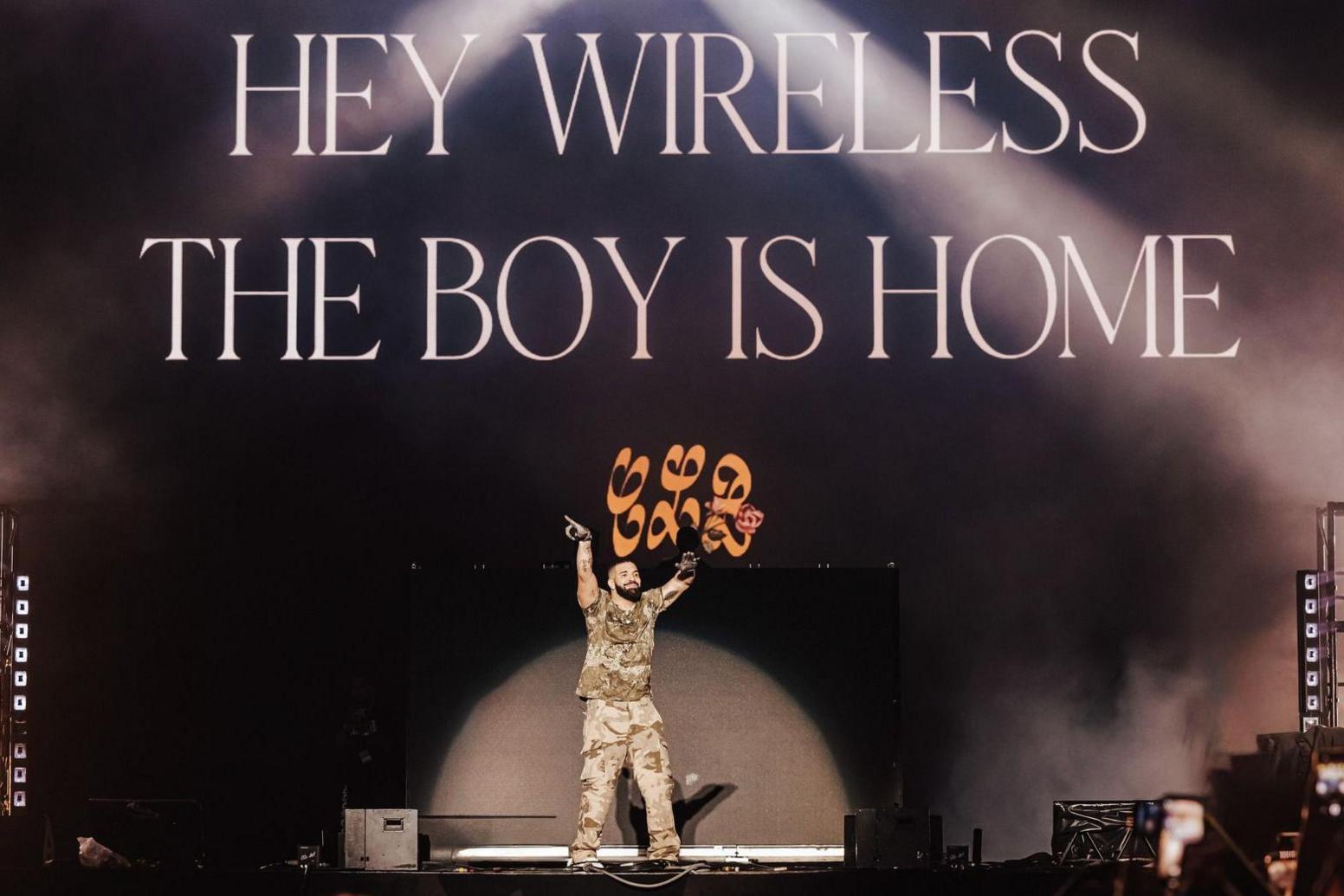 Drake previously onstage at Wireless, arms aloft, with the words "Hey, Wireless, the boy is home" displayed behind him