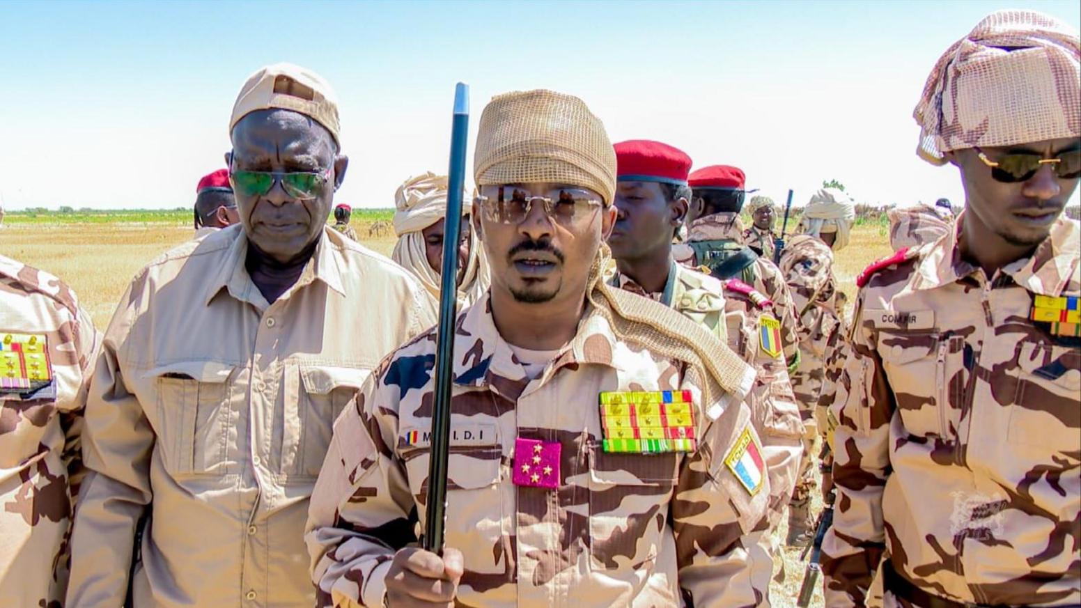 President Mahamat Déby in army uniform standing with other military men.