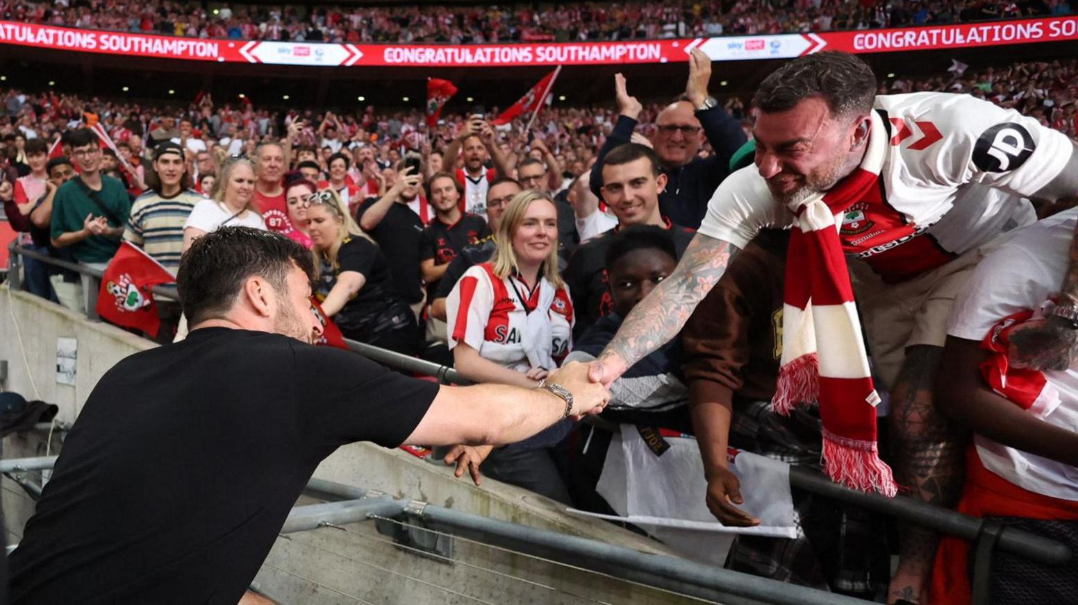 Southampton boss Russell Martin celebrates with fans after the Saints win promotion back to the Premier League