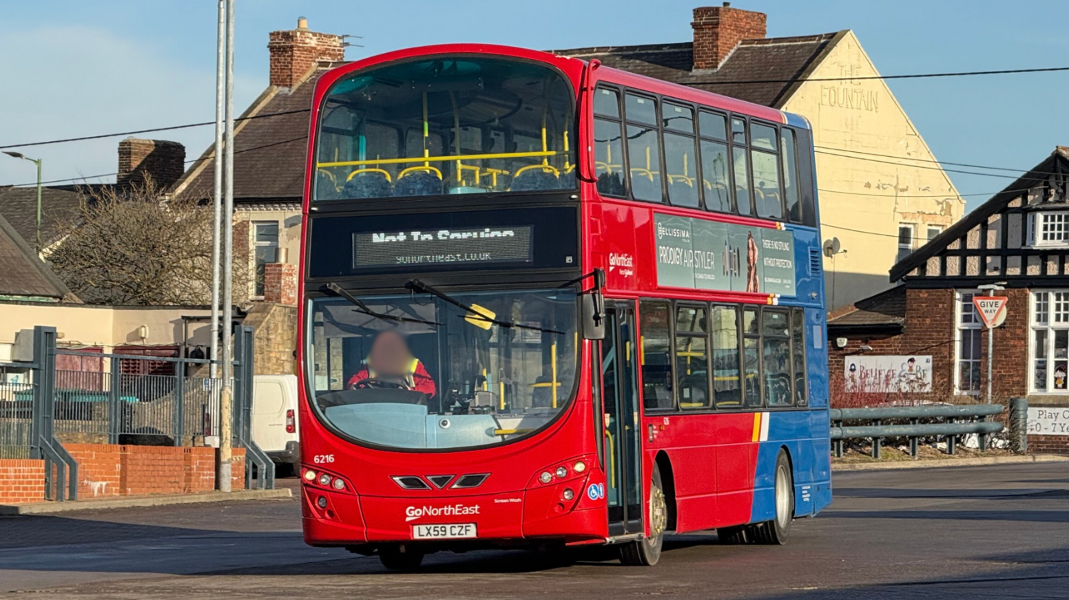 A red and blue painted buses which is displaying 'not in service' on its destination screen