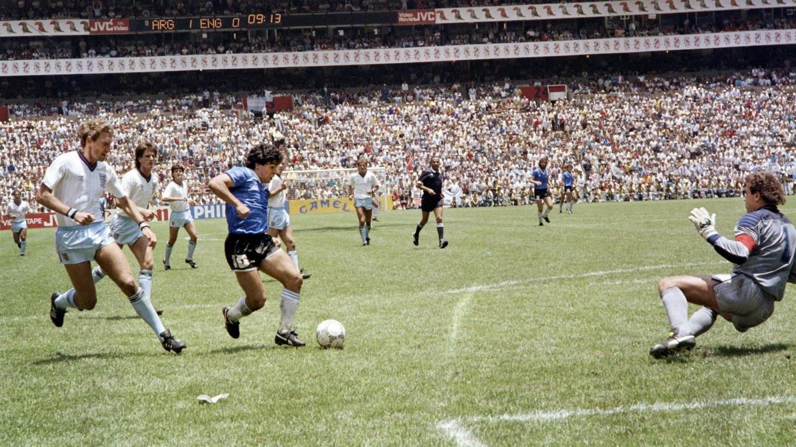 Diego Maradona about to slot the ball past a diving Peter Shilton as Terry Butcher tries to get close