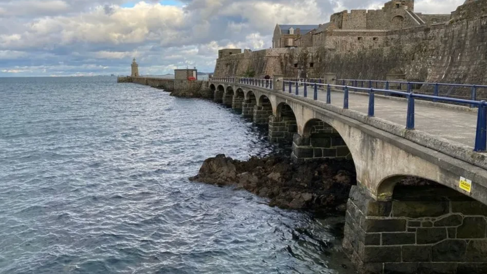 The breakwater bridge at Castel Cornet with the sea on the left.