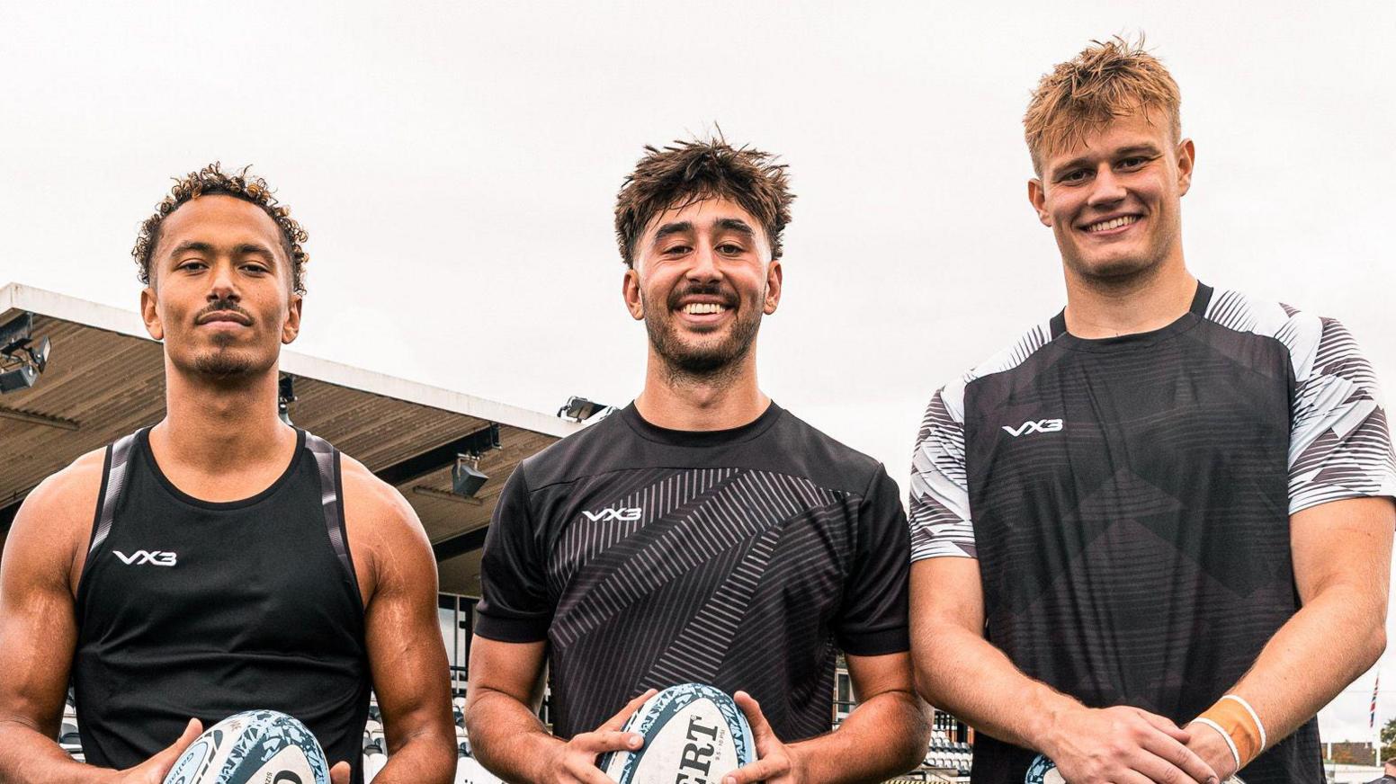 Harrison Obatoyinbo (left), Joel Grayson (centre) and Sam Waugh (right) all holding rugby balls as they look at the camera