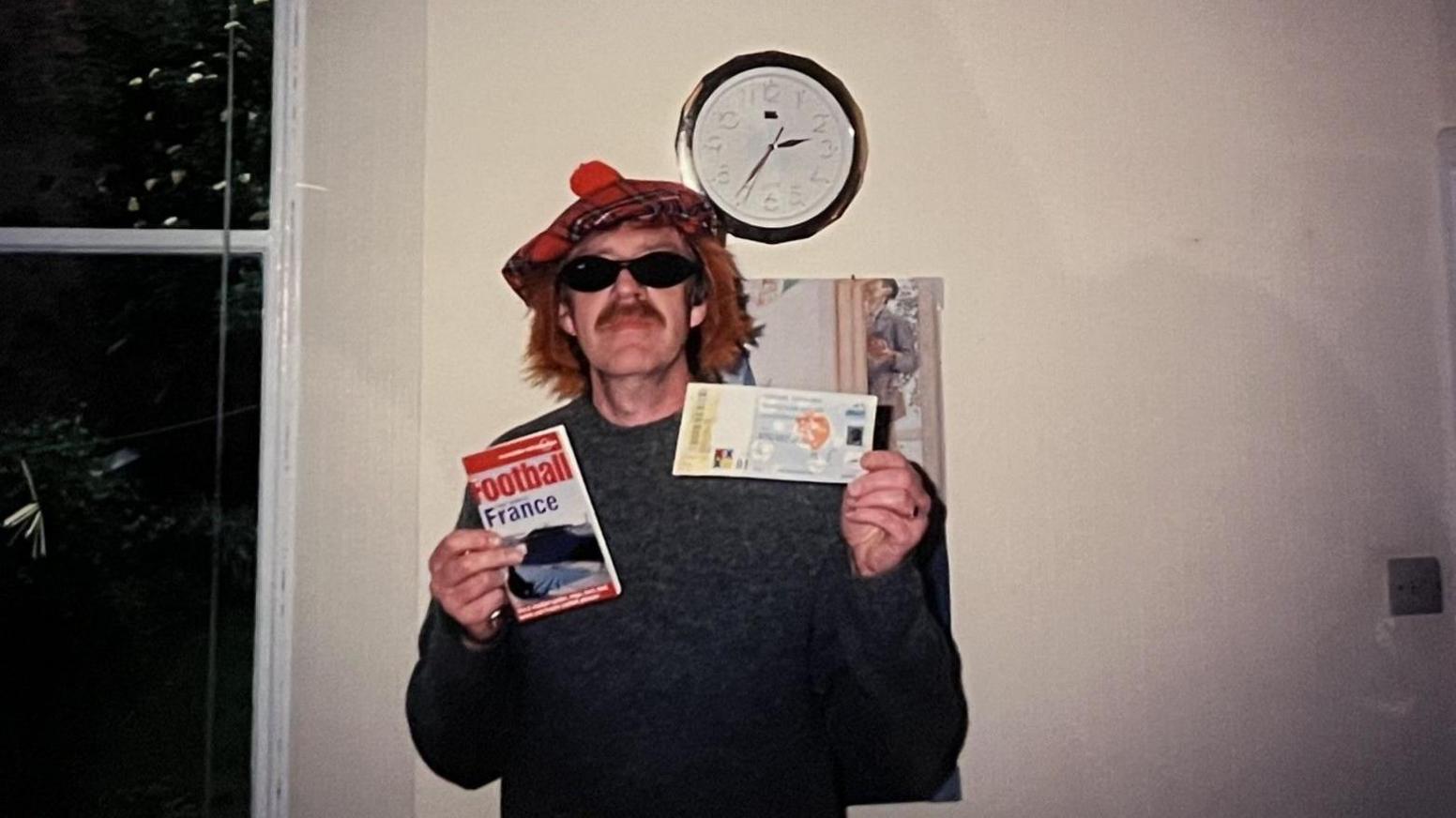 Graham Whitelaw's "disguise" was a tartan tammy and red hair with sunglasses and a fake ginger moustache - he poses here wearing that and showing off his match ticket.