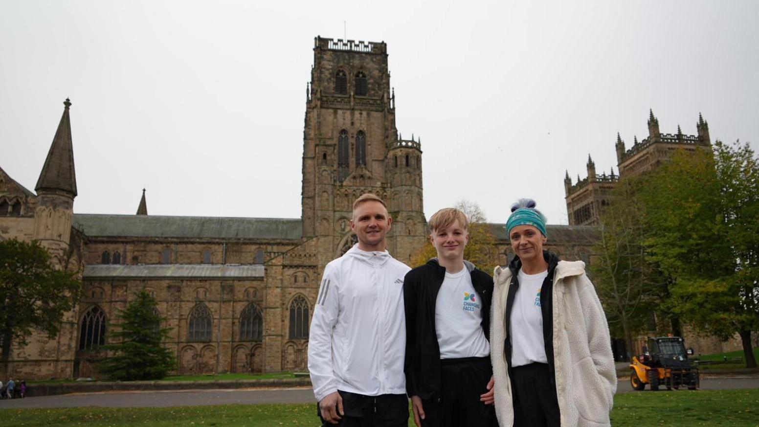 Charlie Graver with his dad Michael on his left and mum Kimberley on his right. They are stood in front of Durham Cathedral ready to start the charity run.