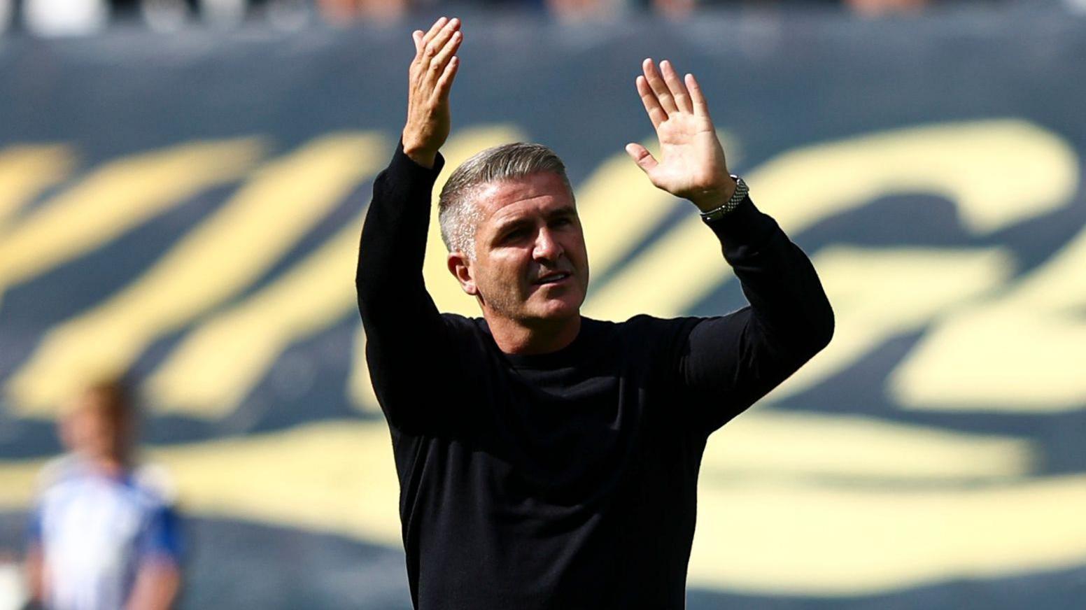 Ryan Lowe waves to Wigan fans