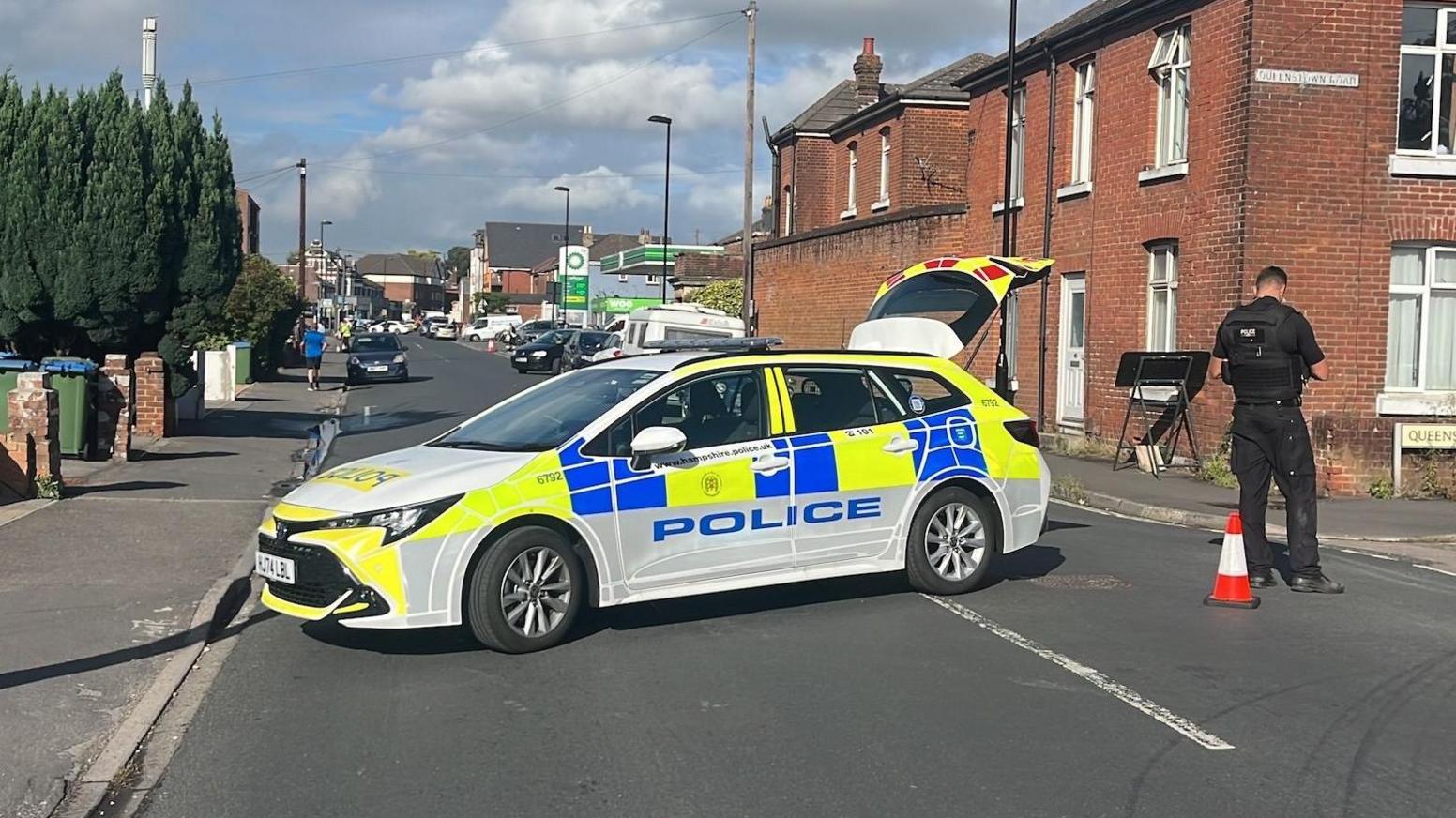 A police car is parked across Paynes Road, blocking traffic.