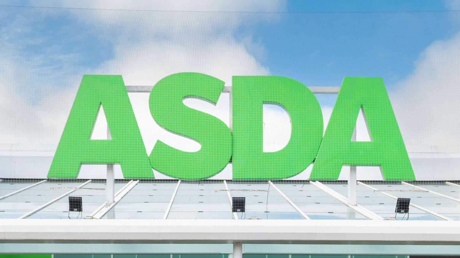 Shop front of Asda close up showing the green A S D A on a glass panel roof