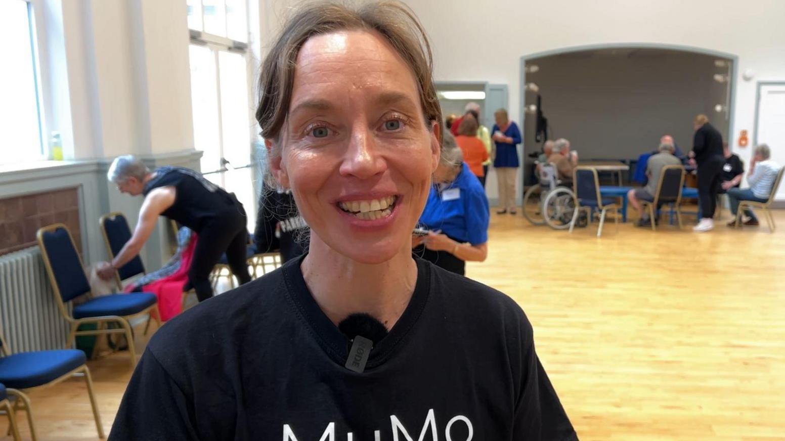 Roosa Leimu-Brown smiling at the camera in a black MuMo creative braded t-shirt