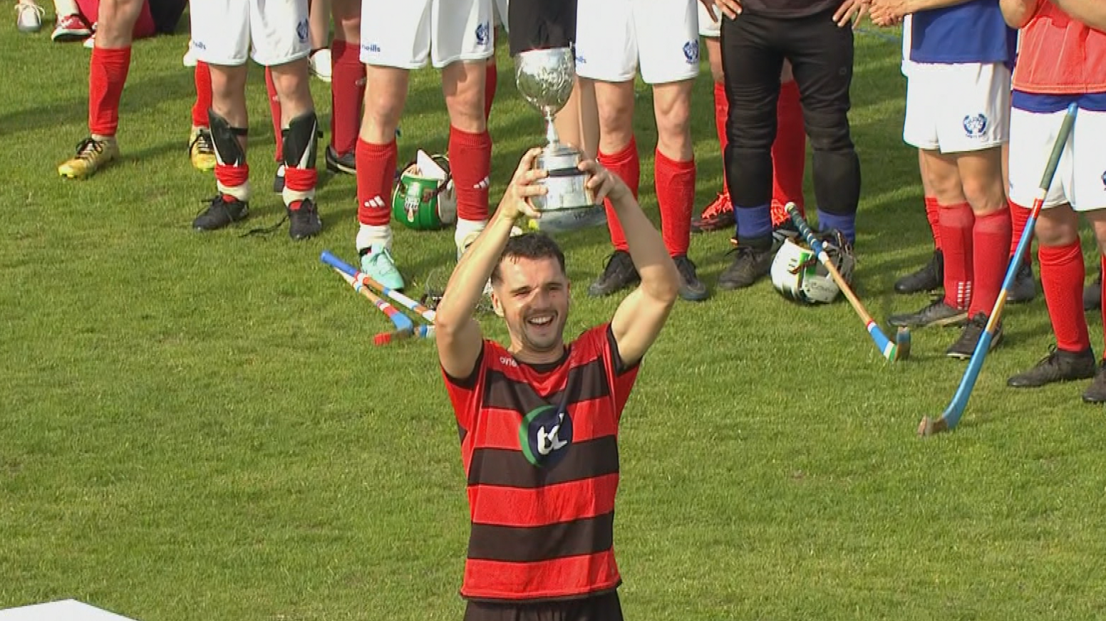 Daniel Mac a' Phiocair a' togail Cupa Comann Ceilteach Ghlaschu airson Camanachd an Òbain