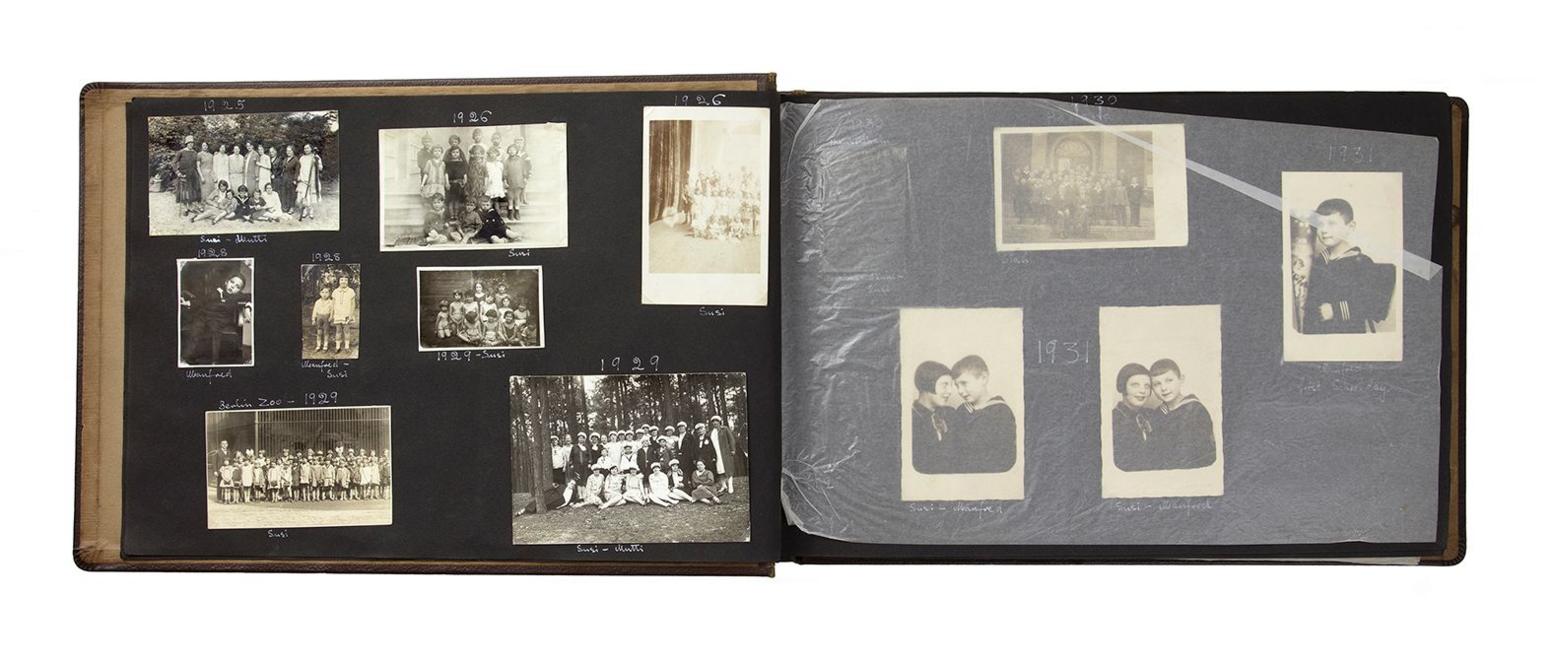 Open pages of Susi’s photo album with black and white photographs on a black background