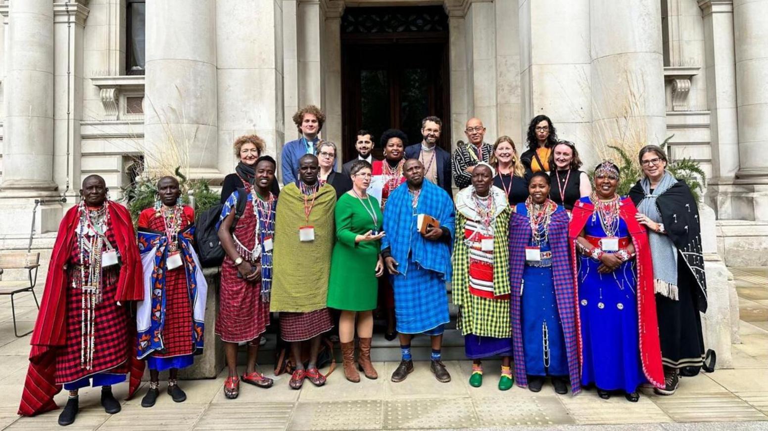 The delegation of Maasai people alongside others stood outside the front of the Pitt Rivers museum. The Maasai stand out with their colourful outfits.