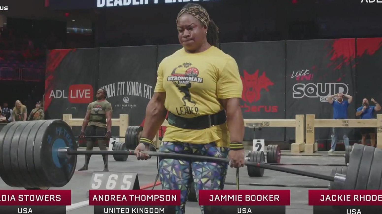 Andrea Thompson strains to assistance a dense barbell weight