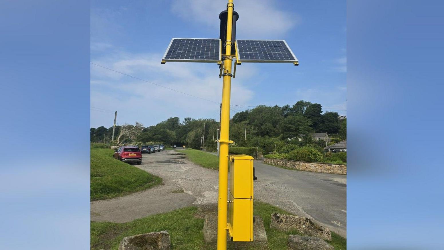 The defibrillator cabinet, pictured from the side to show the solar panels at the top.
