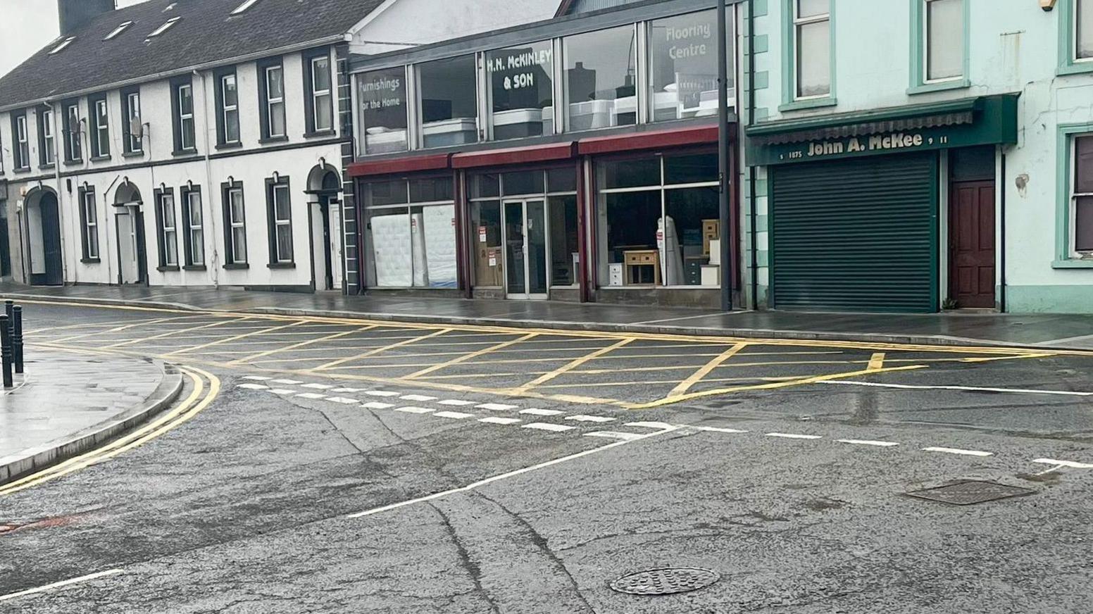 A new yellow box on the road, smaller in size than the original. The photo shows shops in the background.