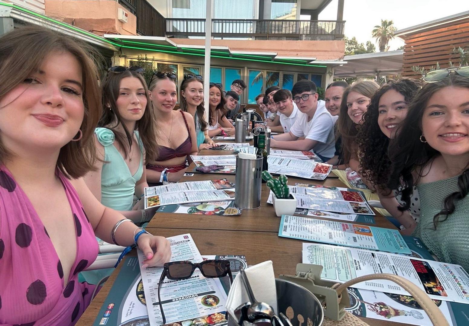 A group of young people sitting at a table at a restaurant in an overseas country