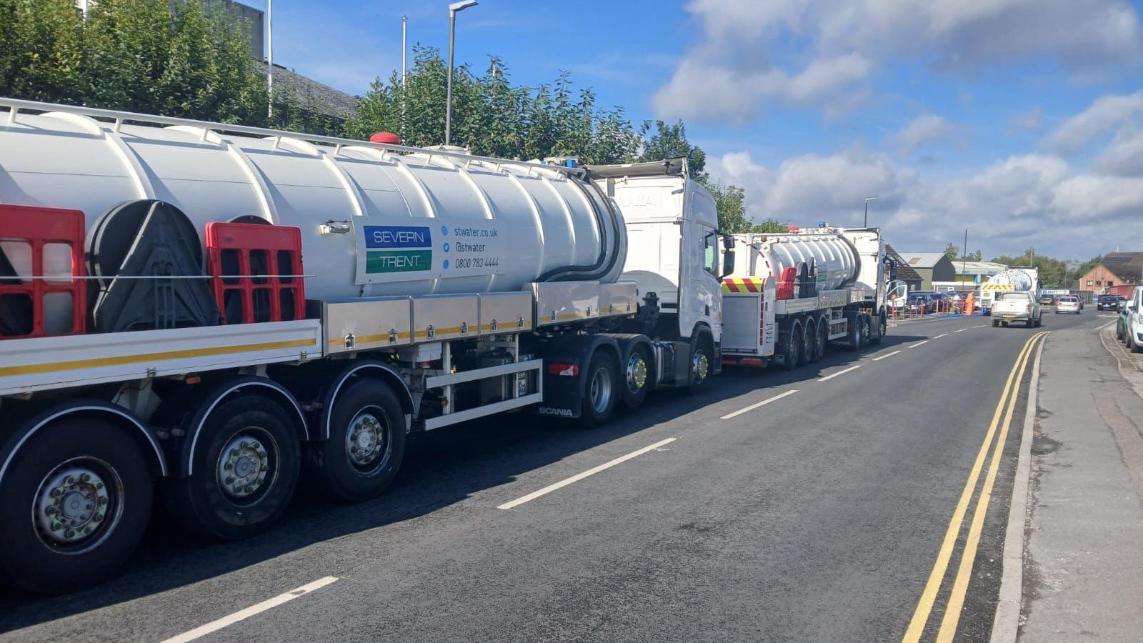 Image of two large water tankers on a road with Severn Trent branding on the side.