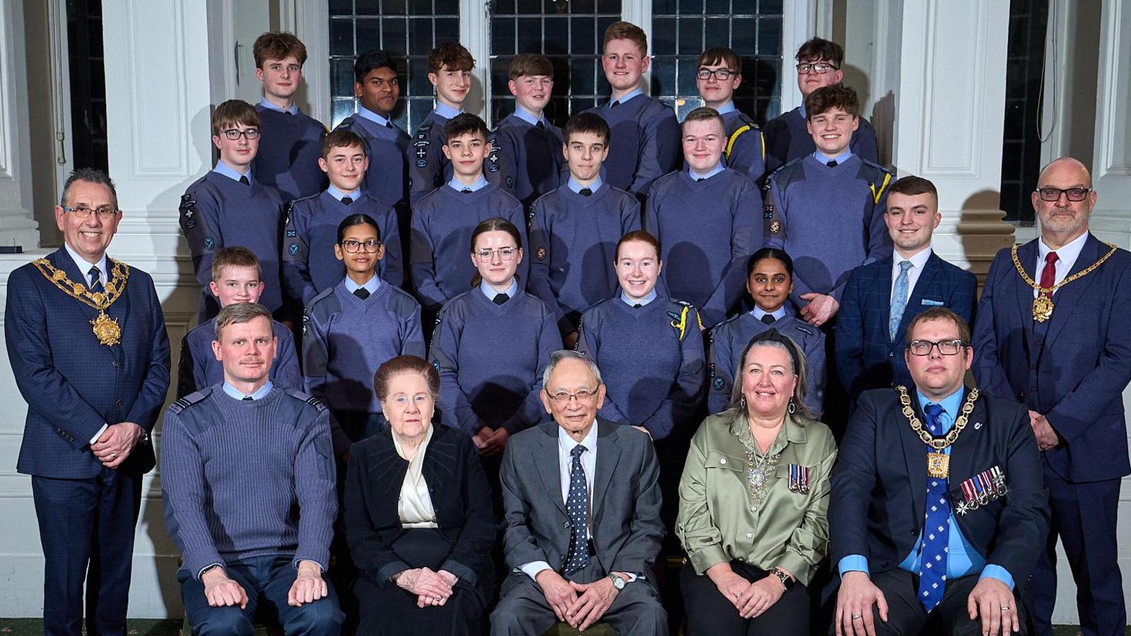 A group of young air cadets pictured with the man whose life was saved at Wakefield Cathedral, Rudy Foo and his wife Diana Foo. The couple are smiling and sat alongside them is the Mayor of Wakefield Darren Byford, Luke Harvey from the Air Cadets, and The Mayor of Mayoress of Featherstone Tracey Austin and Dwain Longley.