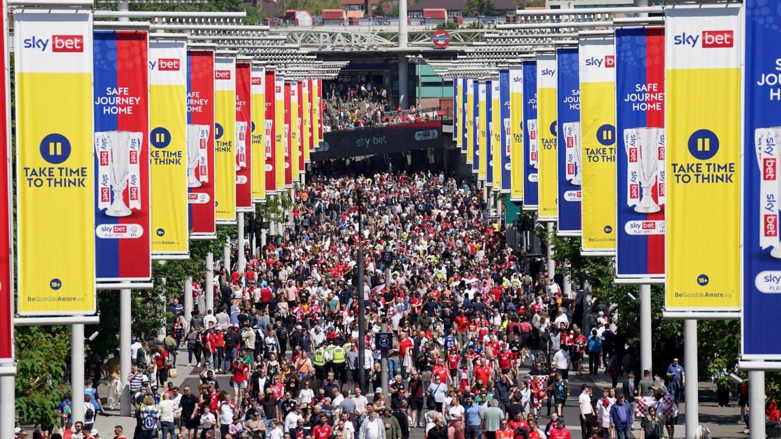 Fans make their way along Wembley Way towards the ground ahead of the game