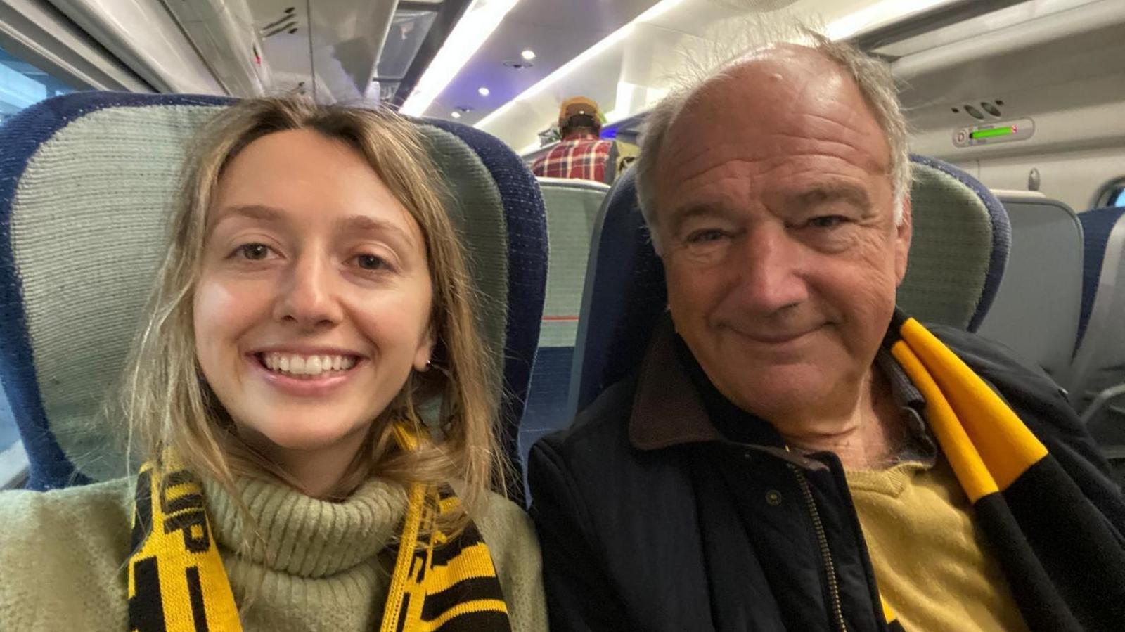 Kate with her father Mark on the train on their way to a Wolverhampton Wanderers football match wearing the merch scarf