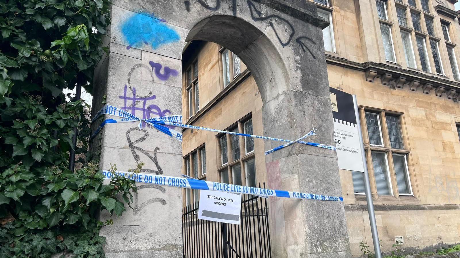 An archway of Norwich Castle has police tape cordoning it off.