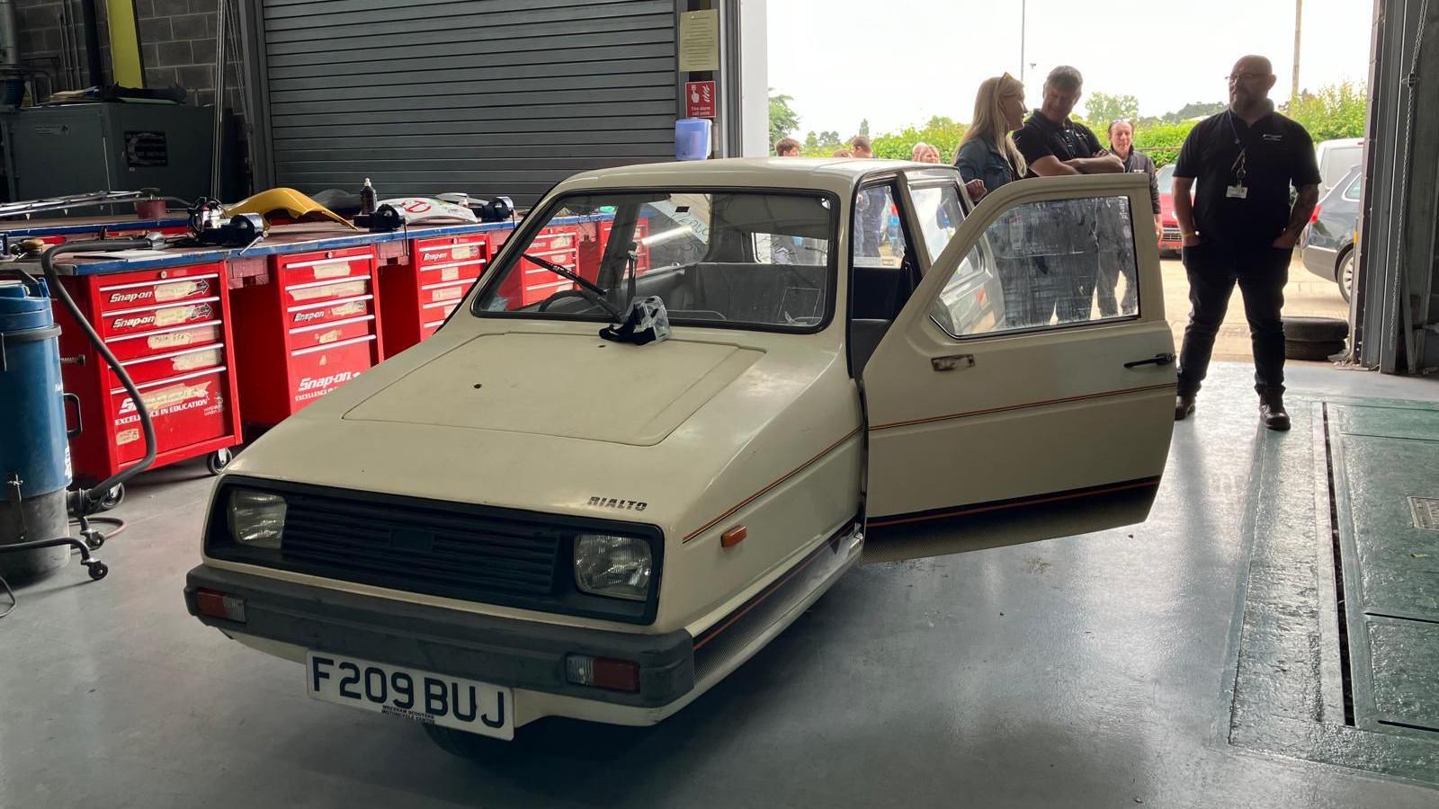 Beige Reliant Rialto with a door open in a workshop