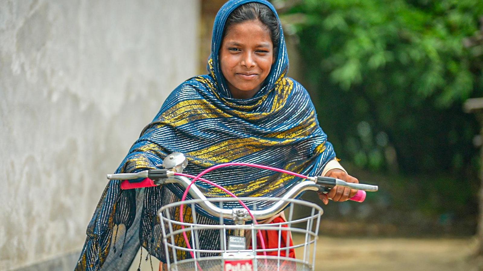 Sabina riding a bike one-handed