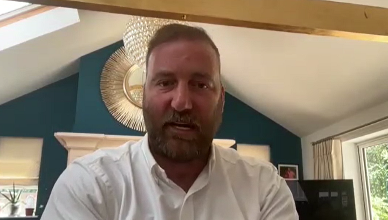 Mr El Paraiso, who has a beard and is wearing a white shirt, sits looking at the camera on a Zoom call with leaseholders that took place in June 2024