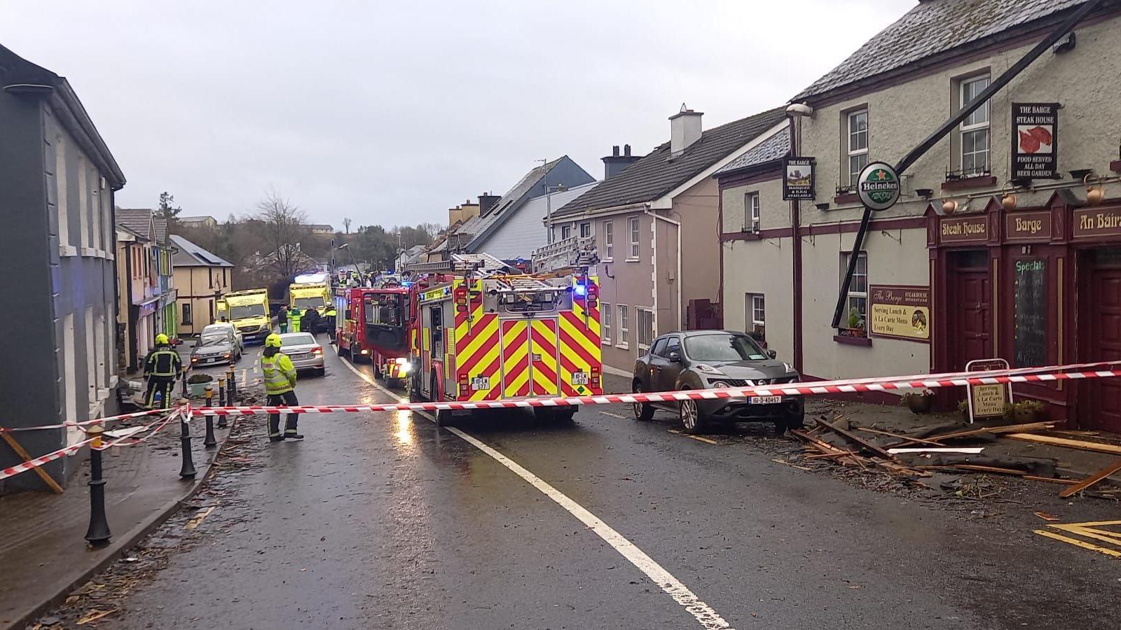 Fire engines behind tape with debris on the road