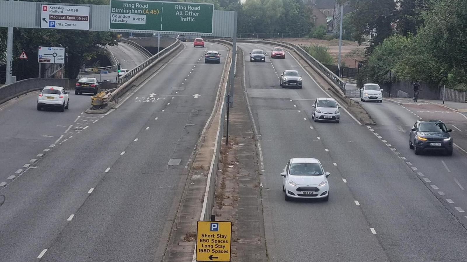 Coventry's ring road showing the two lanes either side of a central reservation with slip roads either side and cars in motion on the road