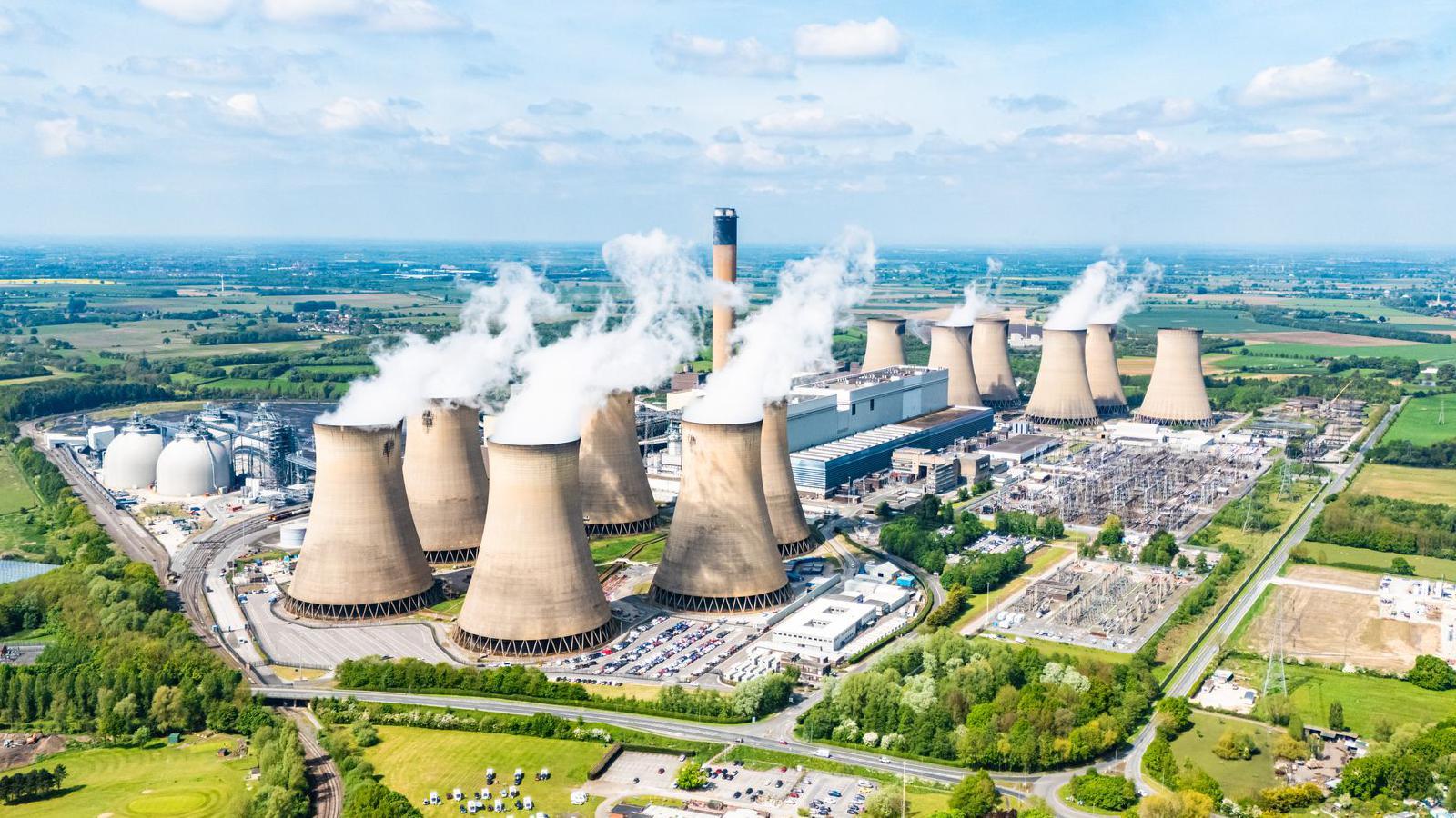 Aerial landscape view of Drax power station with thick white steam rising from cooling towers on a sunny day