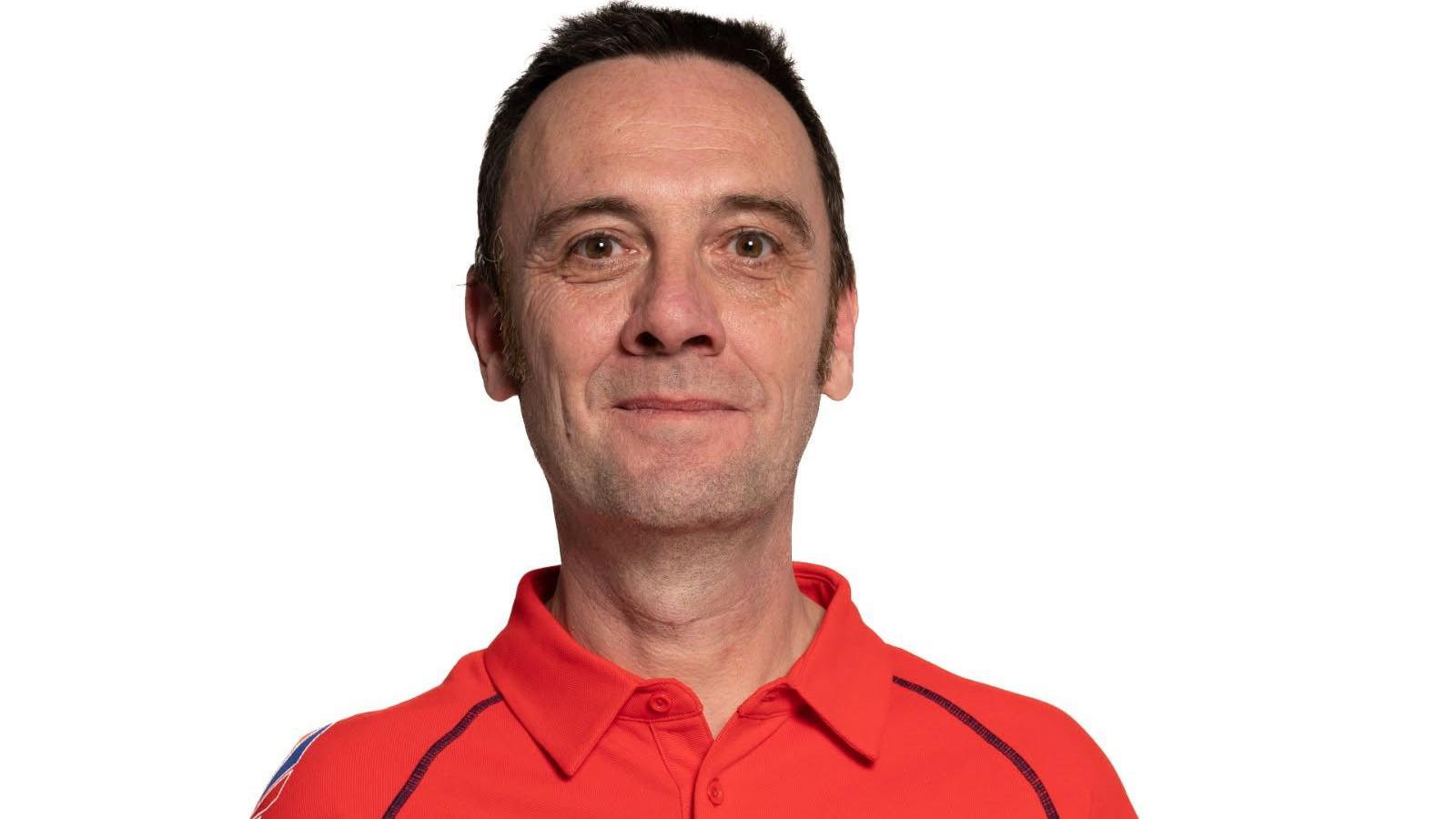 Portrait shot of Jay Saunders, who is wearing a red polo shirt