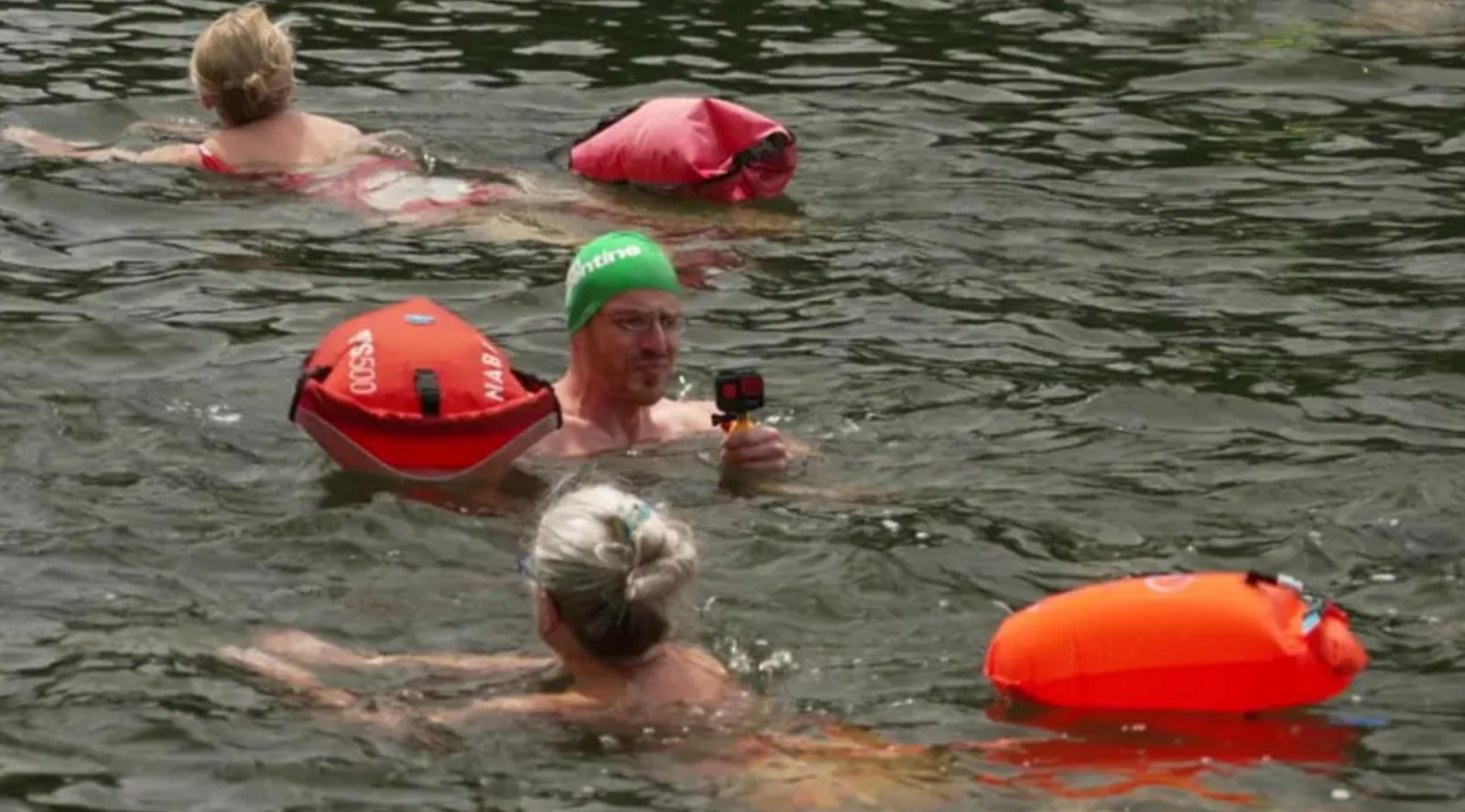 Swimmers in the water with buoys around them