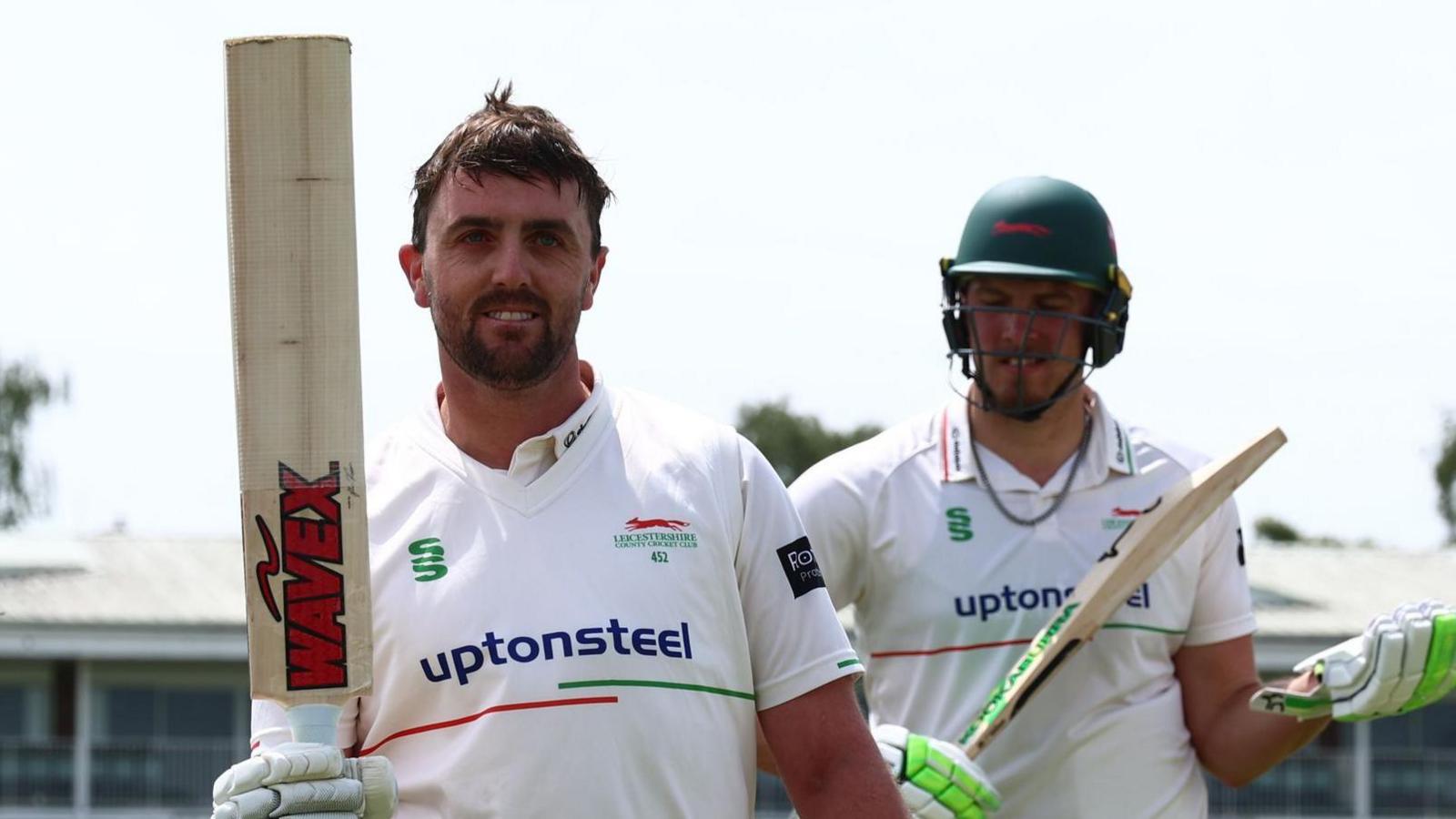 Leicestershire's Lewis Hill hold his bat up as he leaves the field