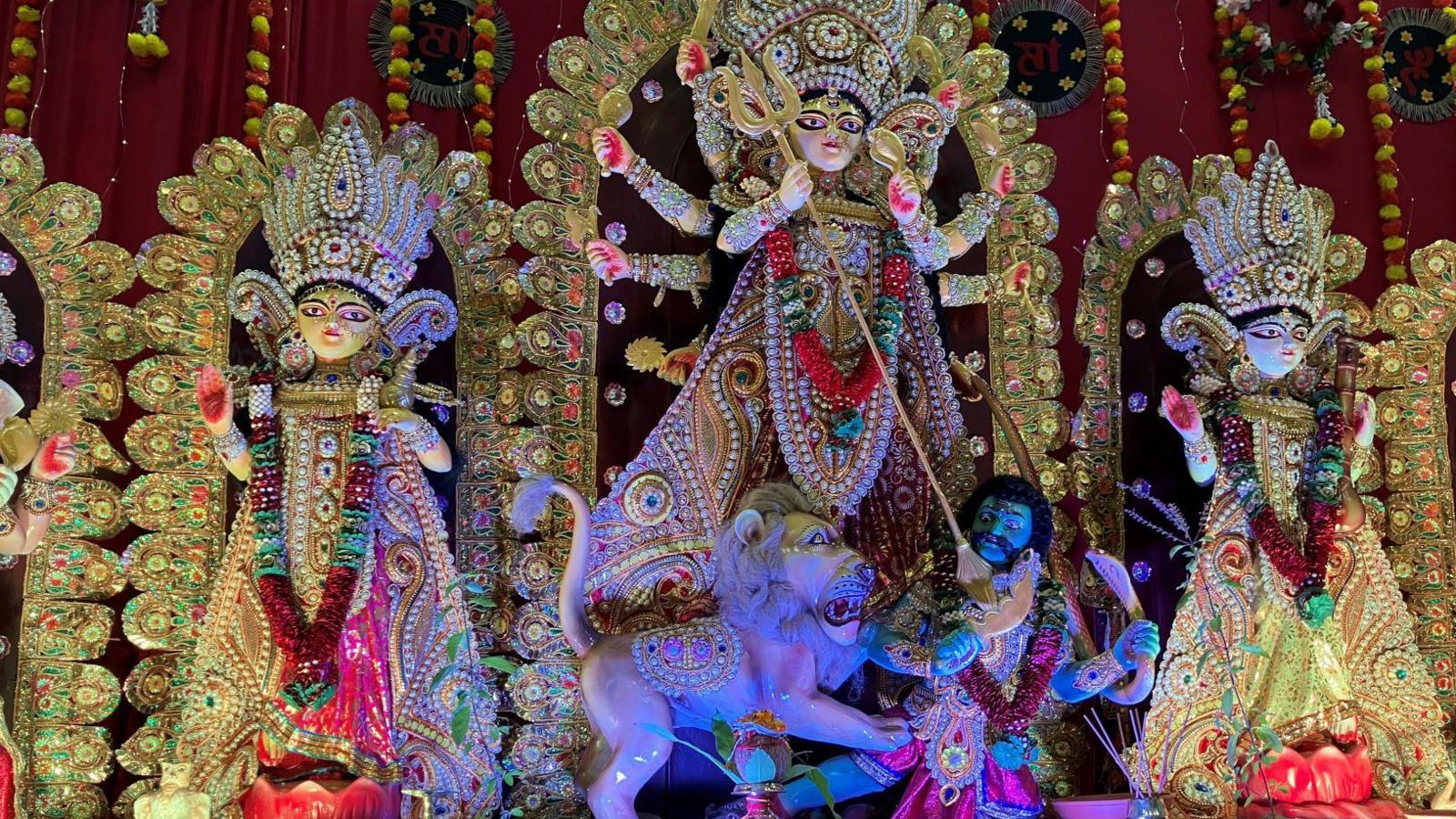 A display of Icons depicting the Hindu goddess Durga and other figures with lots of gold and ornate decorations around them