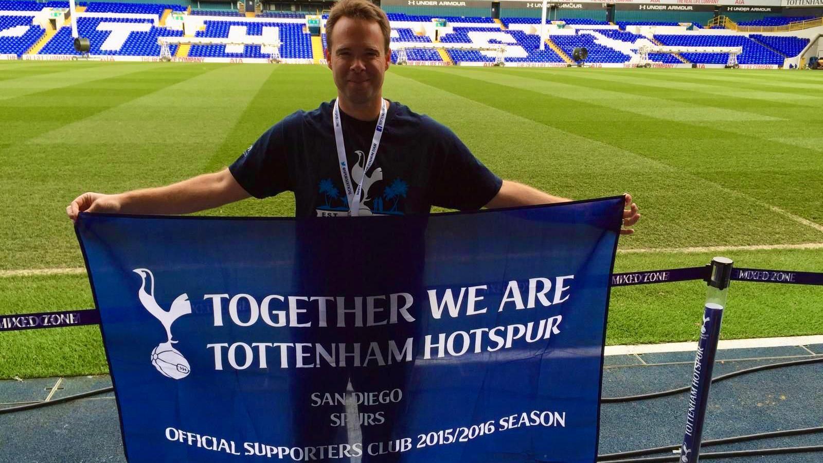 Andrew Smith holds a San Diego Spurs flag at the old White Hart Lane stadium