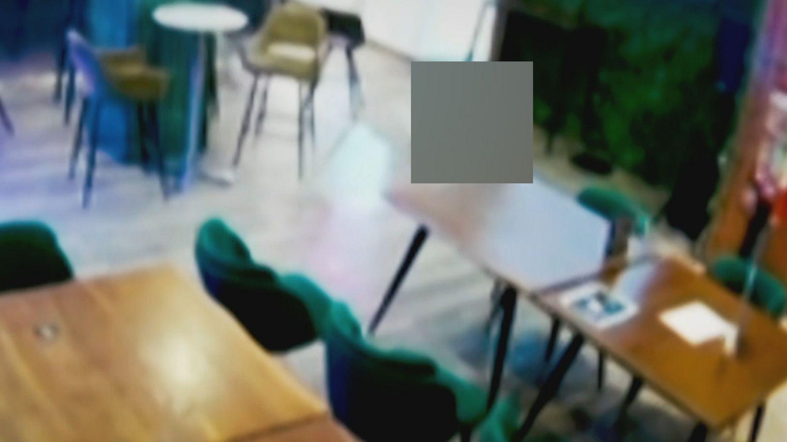 A CCTV image of Ross Monaghan slumped against a table has been blurred out