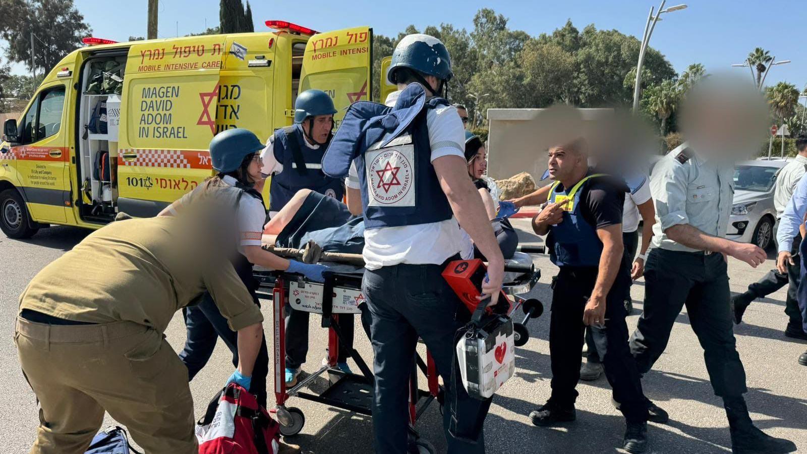 Emergency services wheel a victim on a stretcher at the scene of the incident