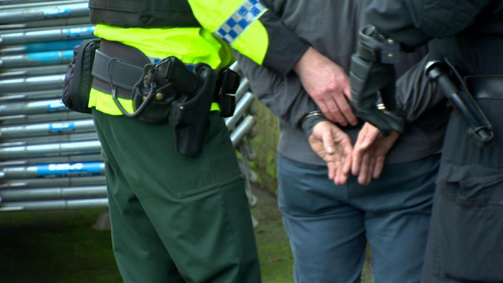 Police officer places man in handcuffs 