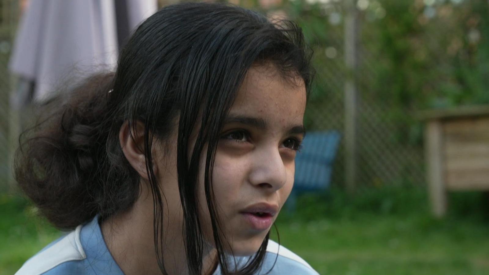 A Palestinian girl sitting in a garden