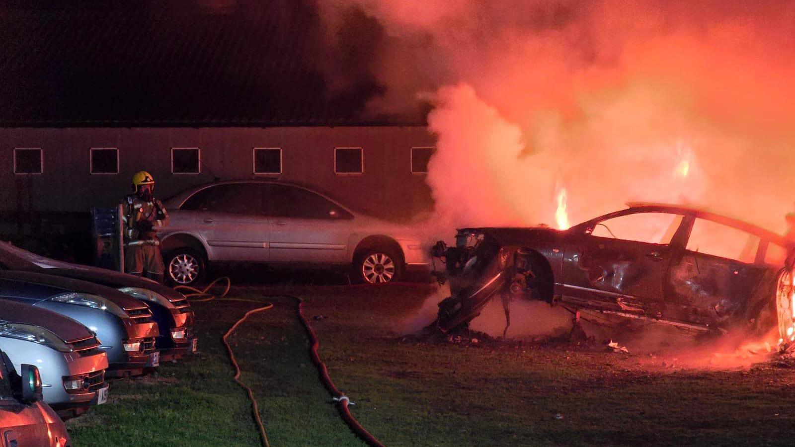 Cars on fire with firefighter fighting