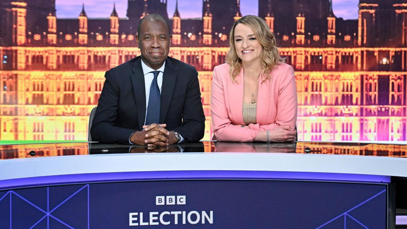 Clive Myrie and Laura Kuenssberg sitting together at a TV studio desk