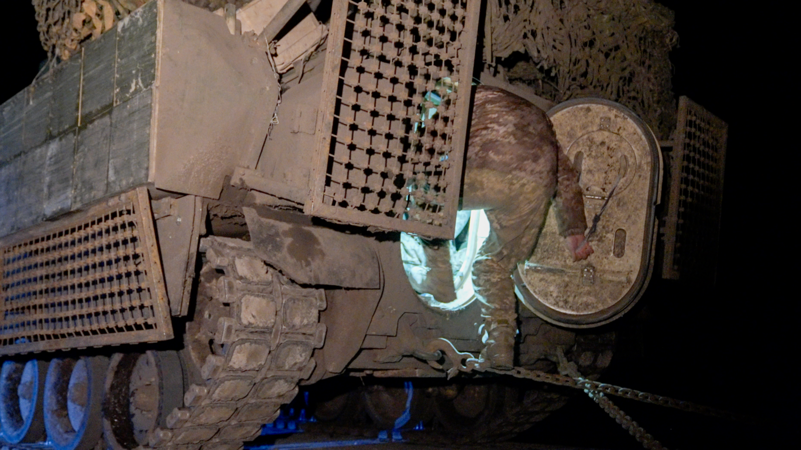 A soldier climbs into the back of a Bradley