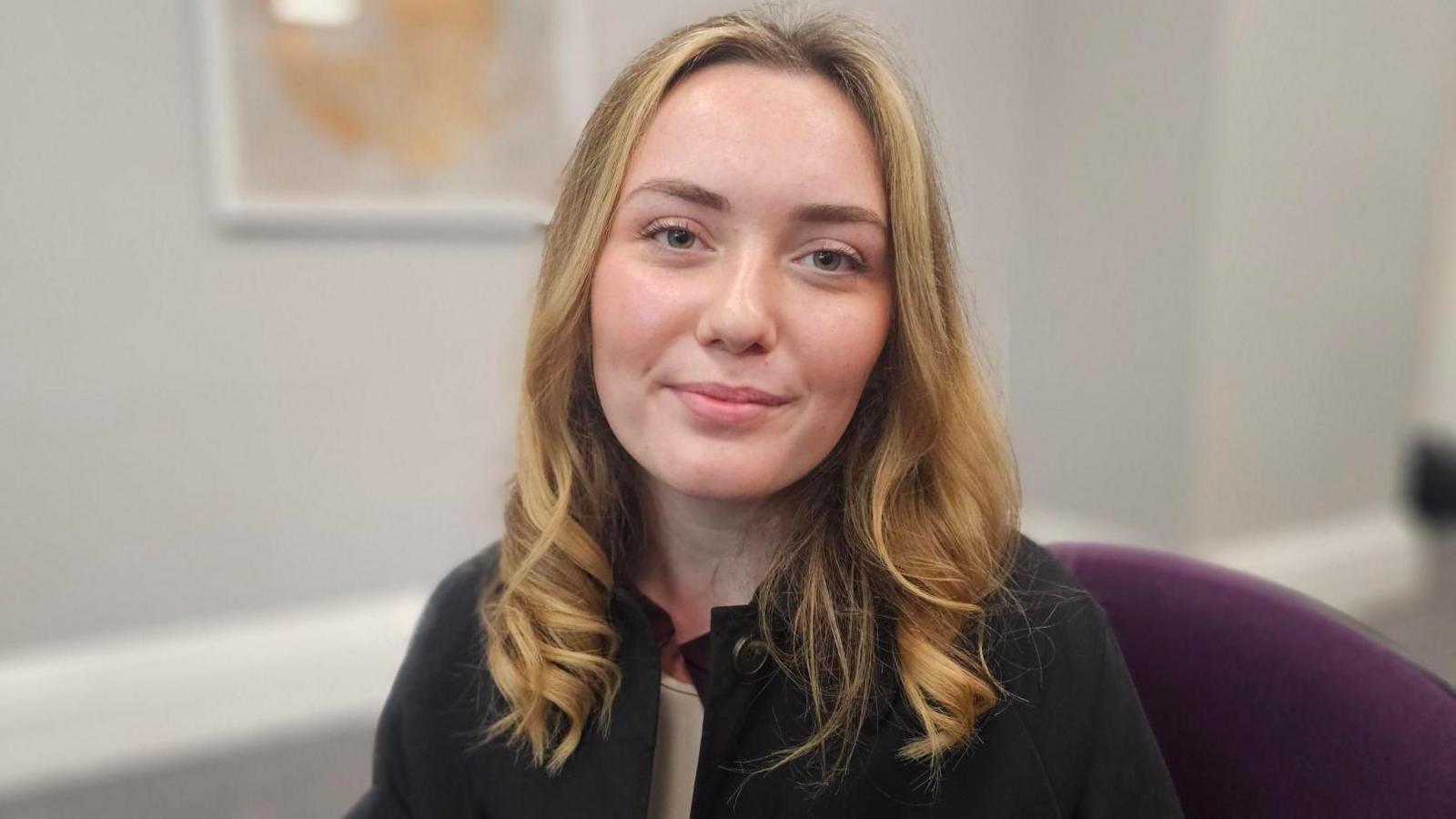 Phoebe Lake, sitting in a chair as part of the presentation