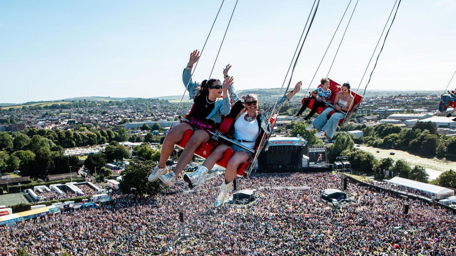 Two people on a high up swing above the main stage