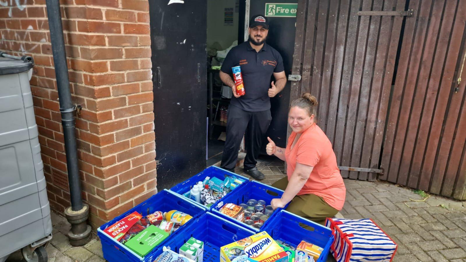 Ozzy Salih and a woman with crates full of food outside the back of Mother's Kitchen.