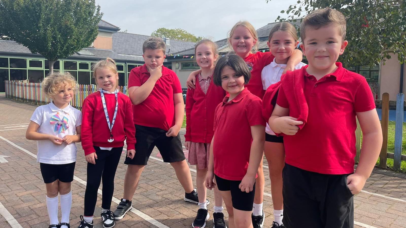 Children in red school uniform posing for a picture at Maes y Morfa Community School in Llanelli