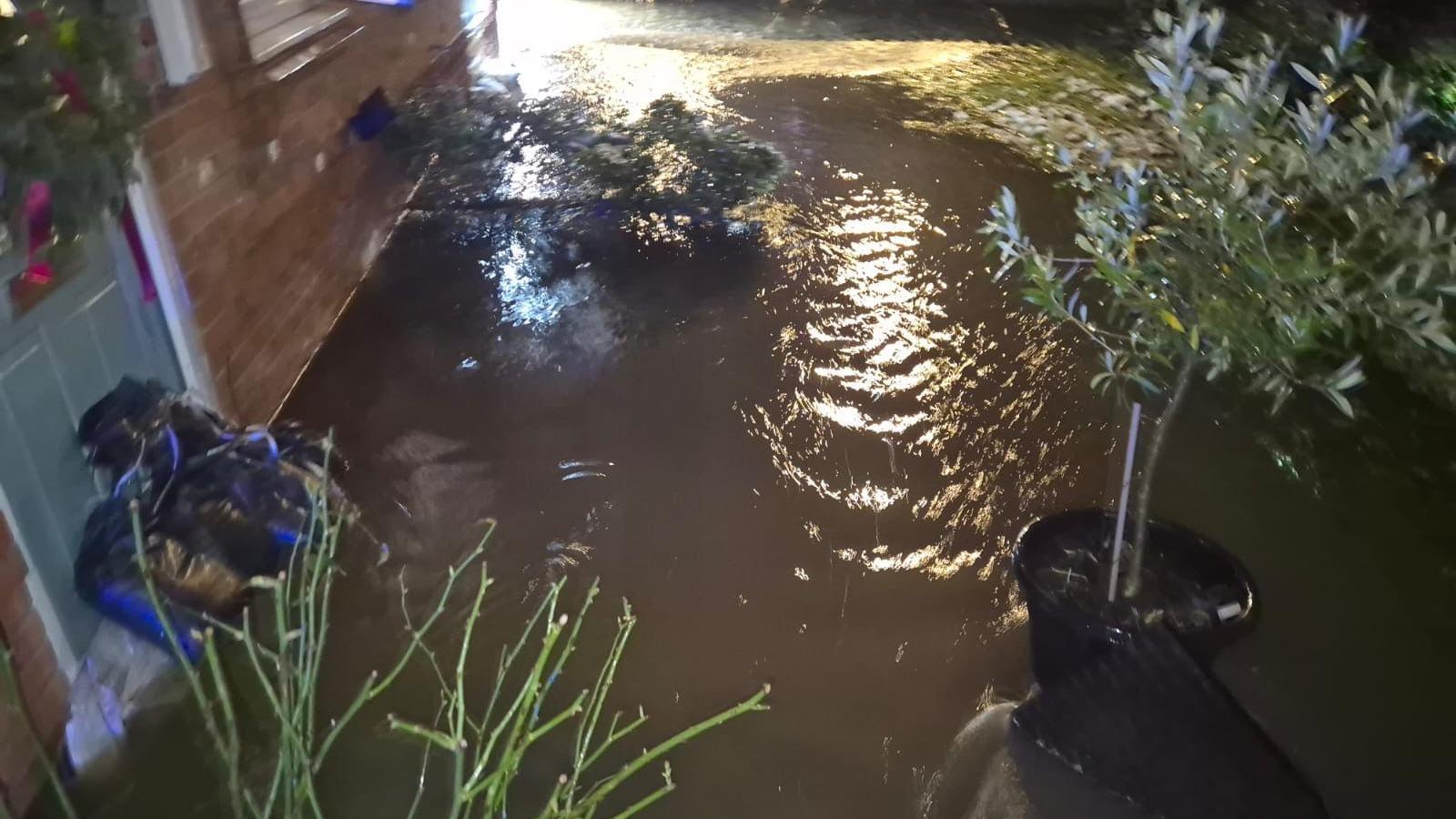 Matty Williams' house and garden with several inches of muddy brook water.