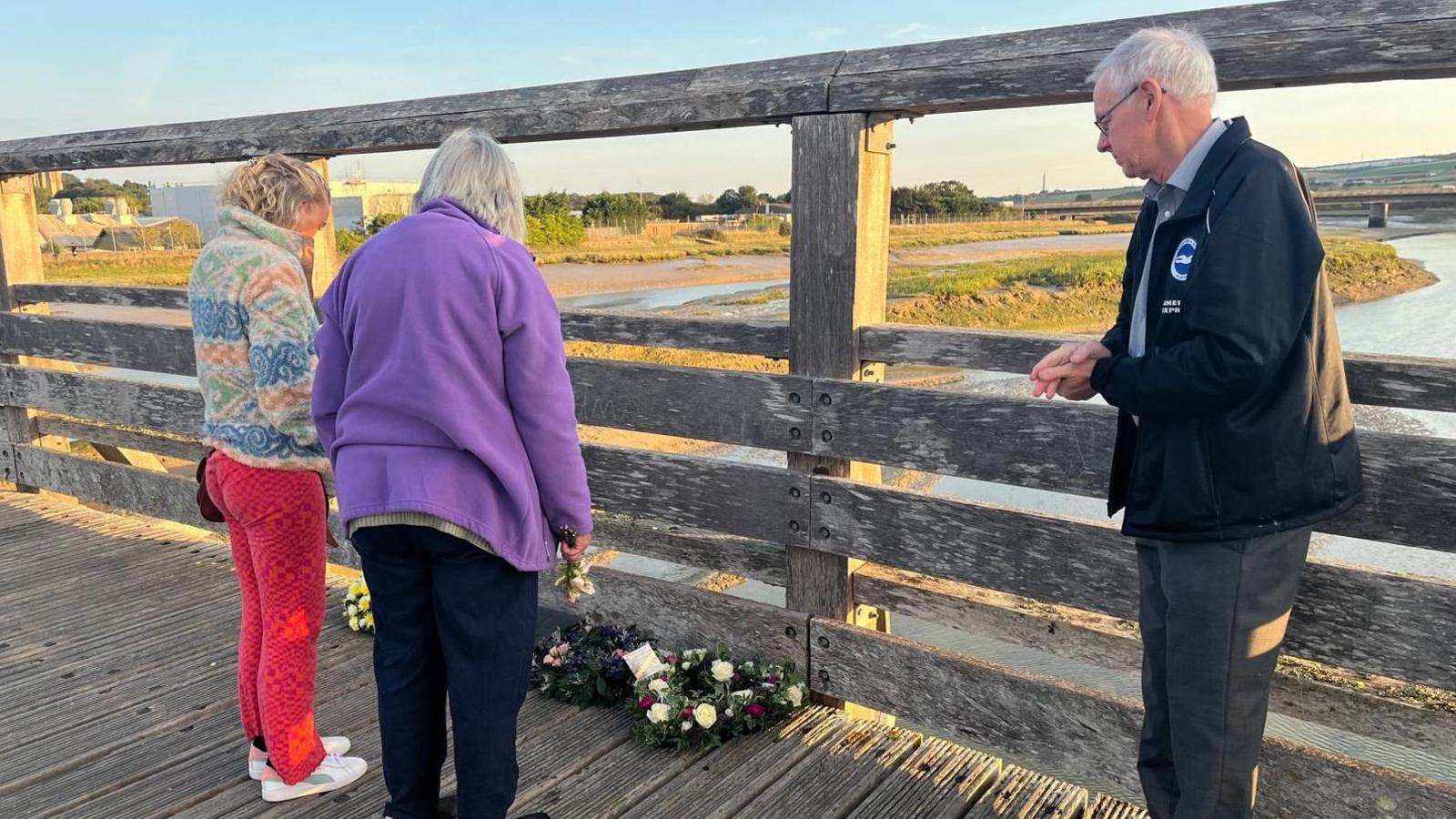 The family of 23-year-old Matthew Grimstone laying flowers on the bridge in Shoreham
